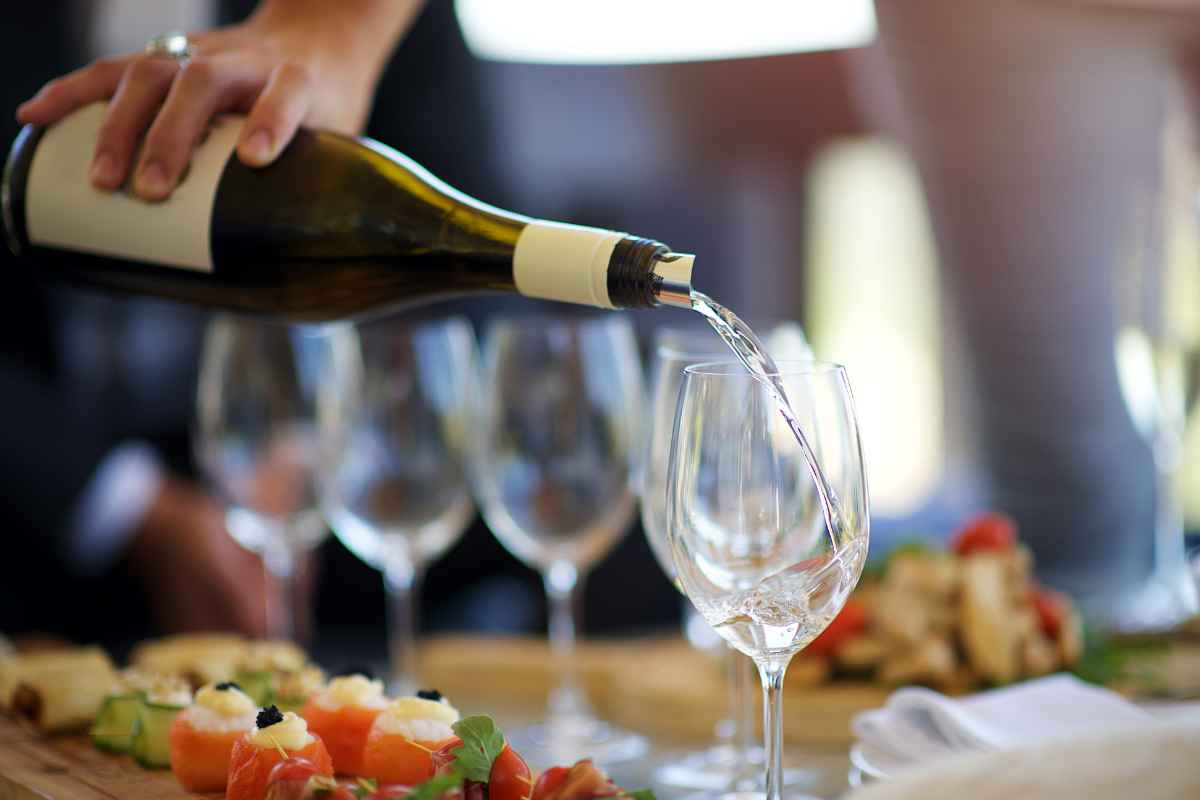 versamento nel calice di un vino bianco per l'aperitivo