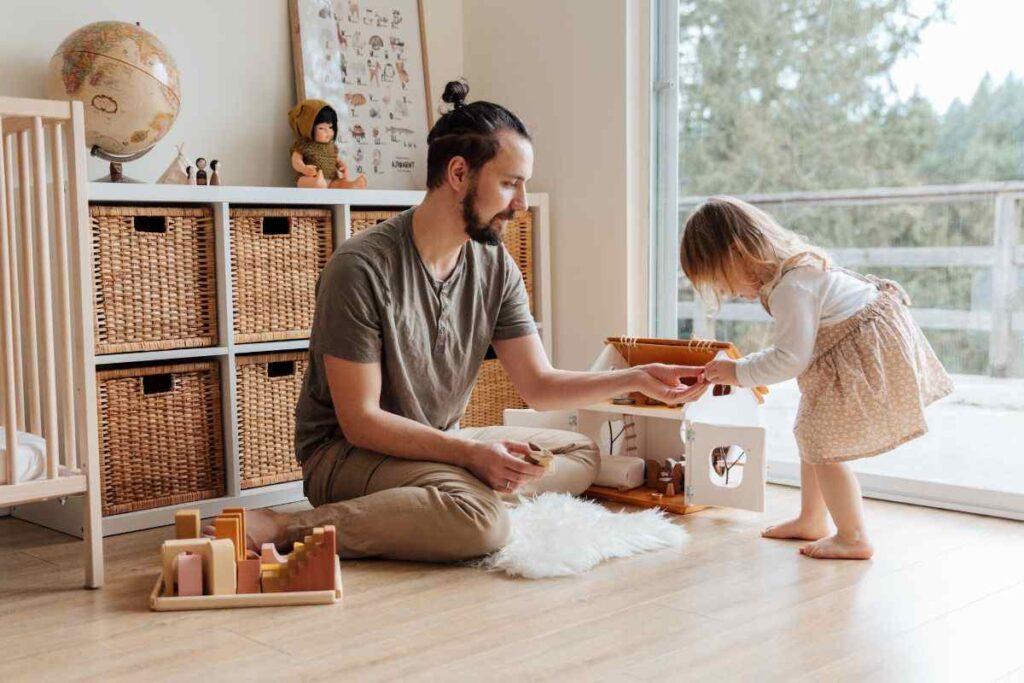 papà che gioca con bambina in cameretta