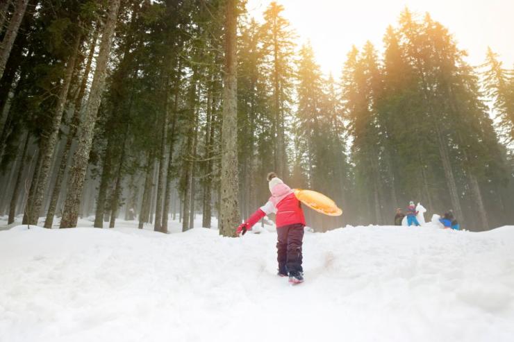 bambino di spalle che gioca sulla neve